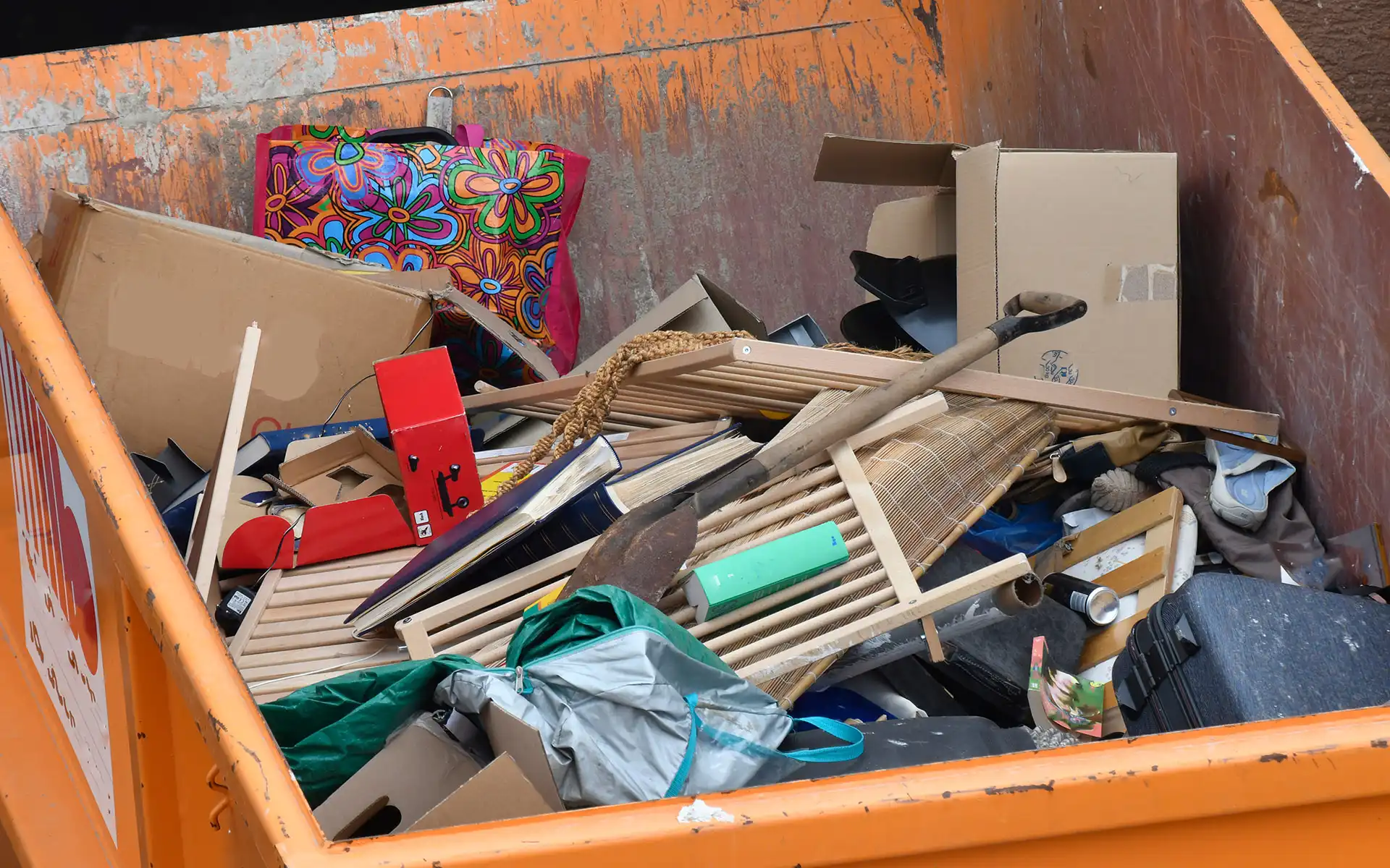 Oranger Müllcontainer voller Entsorgungsgut